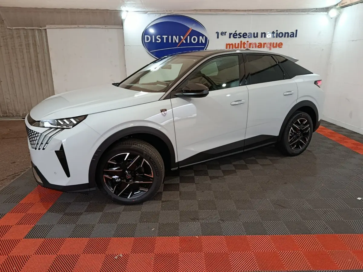Peugeot 3008 1.2 HYBRID 145 GT blanc vue de profil côté gauche en intérieur sur sol à damiers rouge et noir.