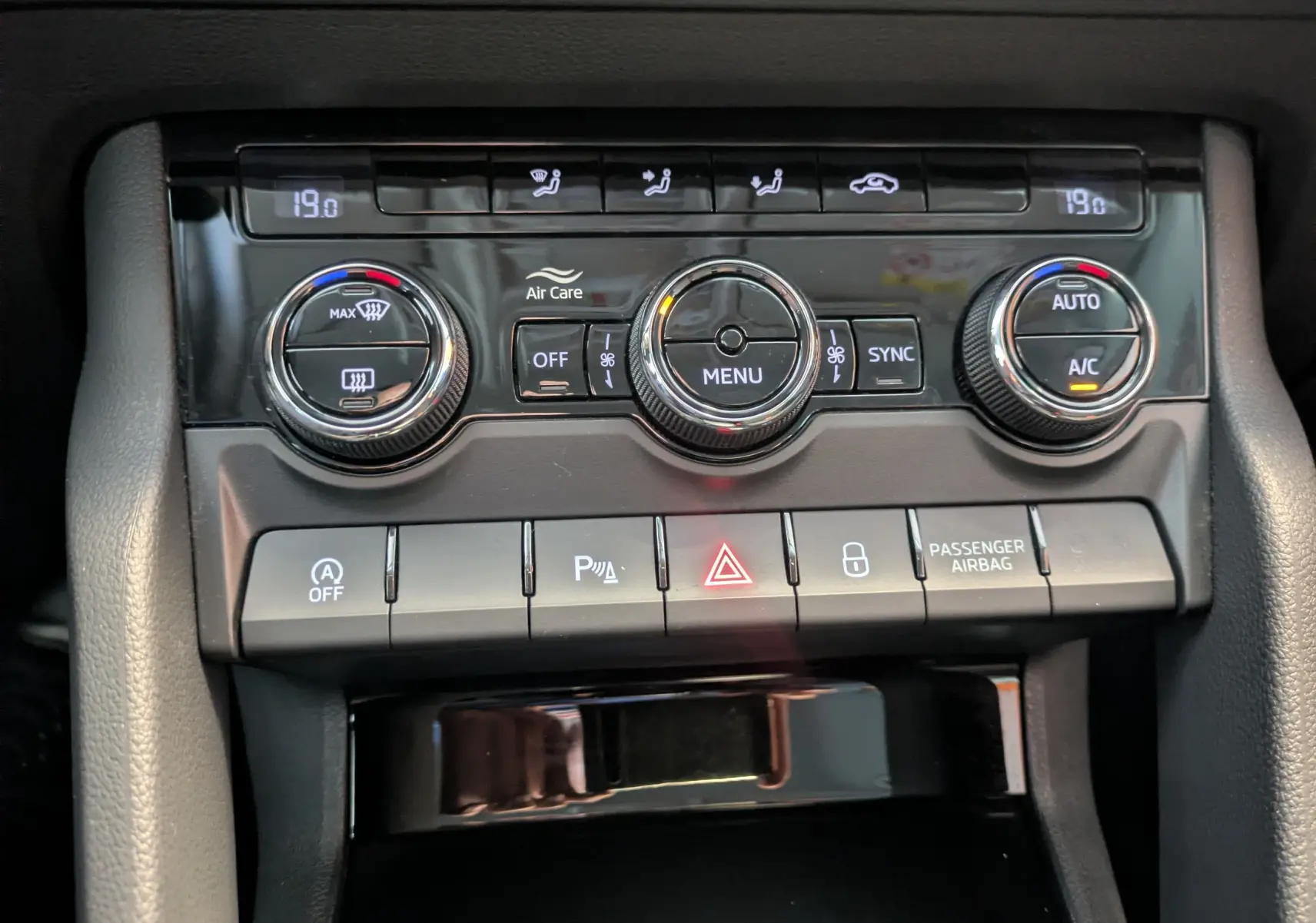 Détail du panneau de commande de la climatisation et des fonctions d’assistance du Skoda Karoq 1.5 TSI gris argent, vue intérieure.