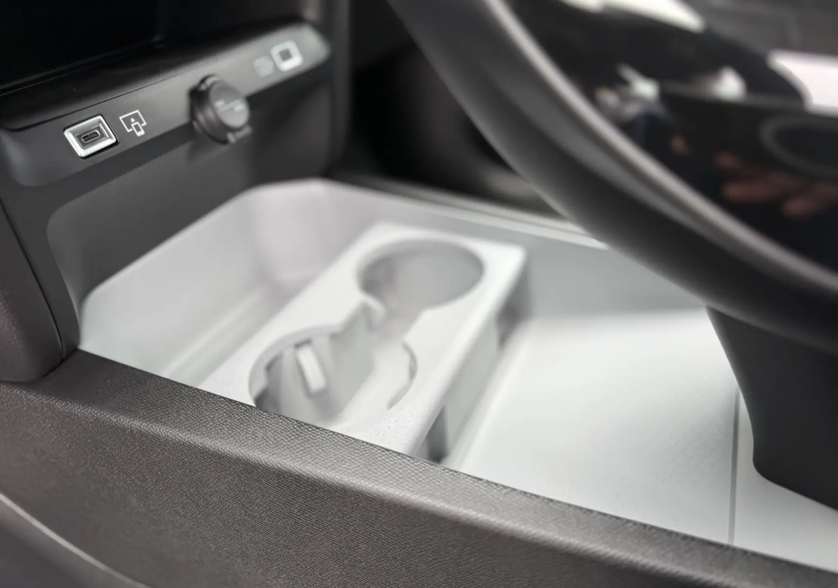 Gros plan sur le rangement central blanc avec porte-gobelets et prises USB dans le Citroën C5 Aircross II Hybrid 2026.