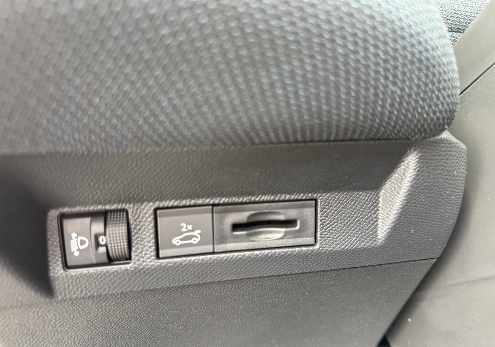 Gros plan sur les commandes d'ouverture du coffre et réglage des phares dans l'habitacle du Citroën C5 Aircross vert Astoria.