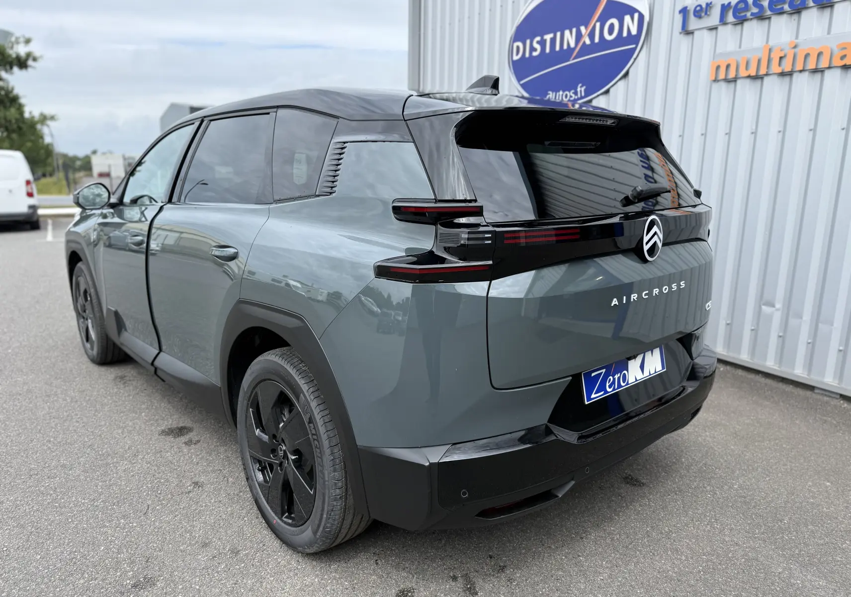 Vue 3/4 arrière droite du Citroën C5 Aircross hybride 2026 vert Astoria avec toit noir et jantes noires.