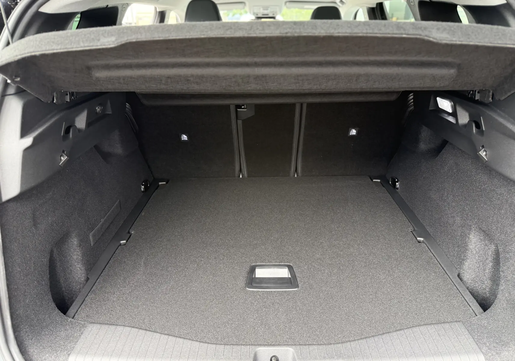 Vue intérieure du coffre spacieux et propre du Citroën C5 Aircross hybride 2026, avec cache-bagages relevé.