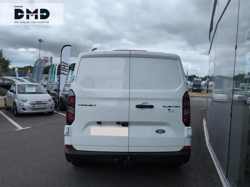 Vue arrière d’un Ford Transit Custom blanc Glacier, portes battantes fermées, avec logo et feux arrière foncés.