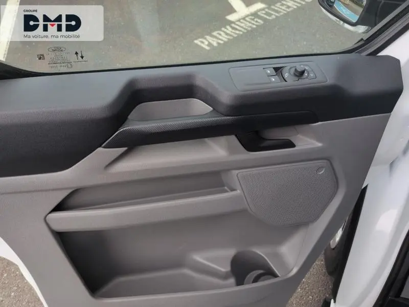 Détail de la porte avant droite du Ford Transit Custom blanc glacier avec commandes électriques et haut-parleur intégré.