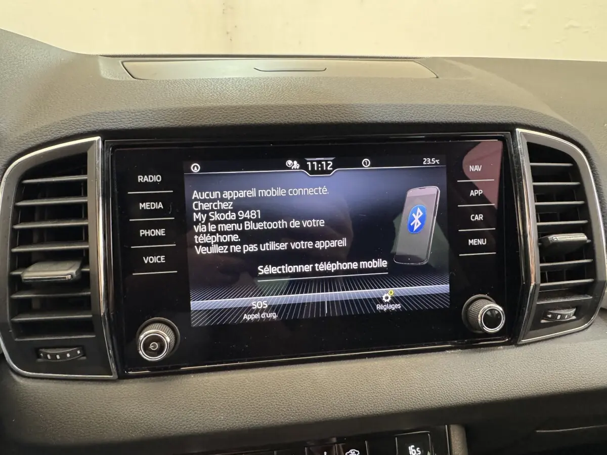 Écran tactile central du tableau de bord du Skoda Karoq blanc 2024 affichant la connexion Bluetooth.