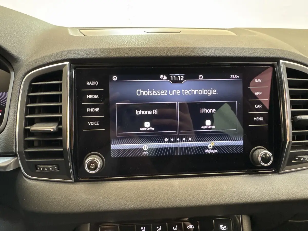 Écran tactile central du tableau de bord du Skoda Karoq blanc 2024 affichant le menu Apple CarPlay.