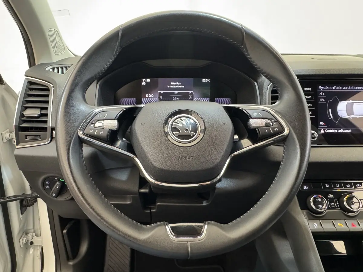 Vue rapprochée du volant cuir noir du Skoda Karoq 2024 avec tableau de bord digital et écran tactile central.