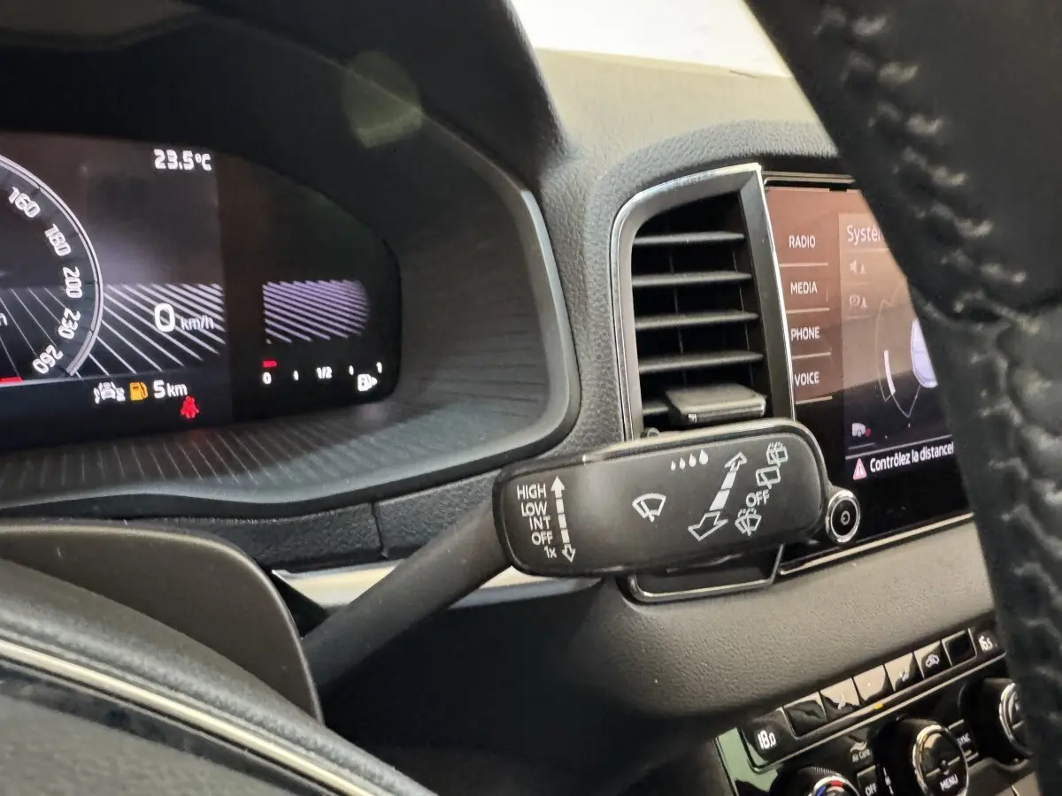 Vue intérieure du combiné d'instruments et du commodo d'essuie-glace d'un Skoda Karoq blanc 2024.