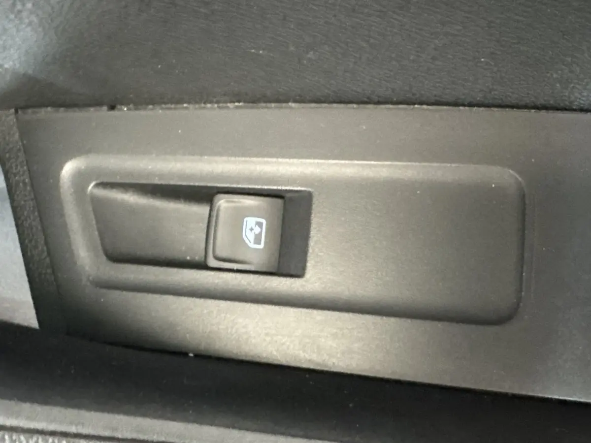 Bouton de commande électrique de lève-vitre côté intérieur d'une porte de Skoda Karoq blanc 2024.