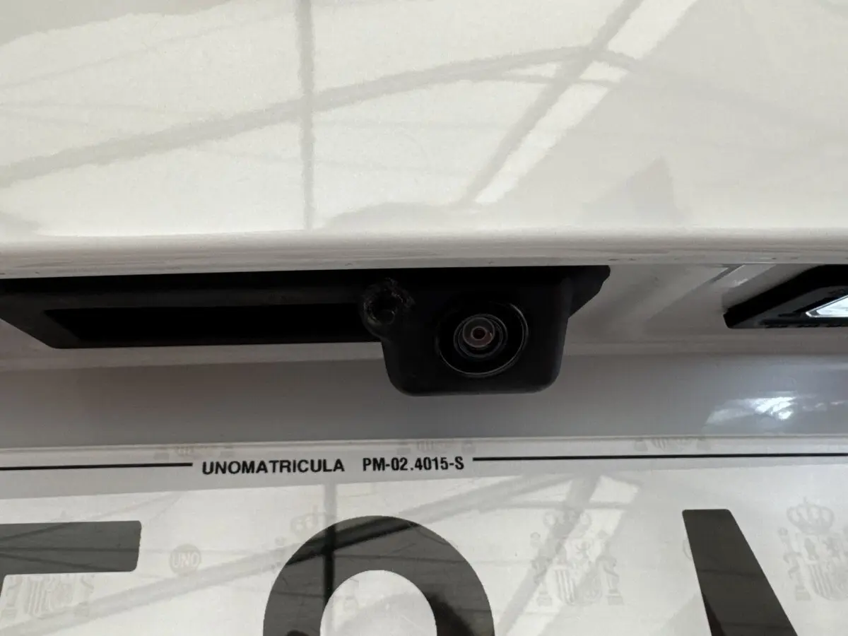 Gros plan sur la caméra de recul au-dessus de la plaque d’immatriculation d’un Skoda Karoq blanc.