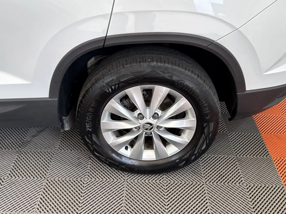 Gros plan sur la roue arrière droite d’un Skoda Karoq blanc 2024 avec jante alliage et pneu Continental.