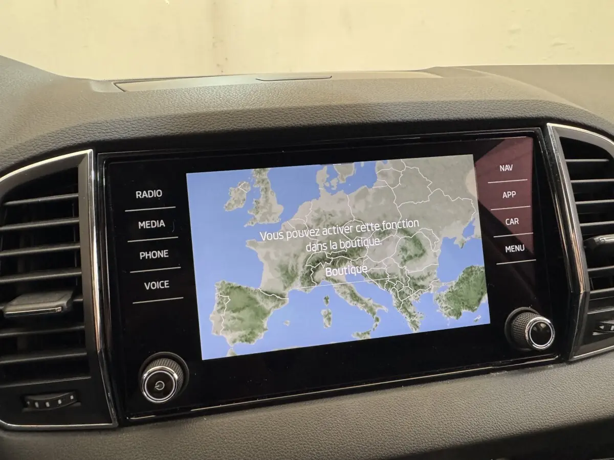 Écran tactile central du tableau de bord du Skoda Karoq 2024 affichant une carte de navigation en mode boutique.