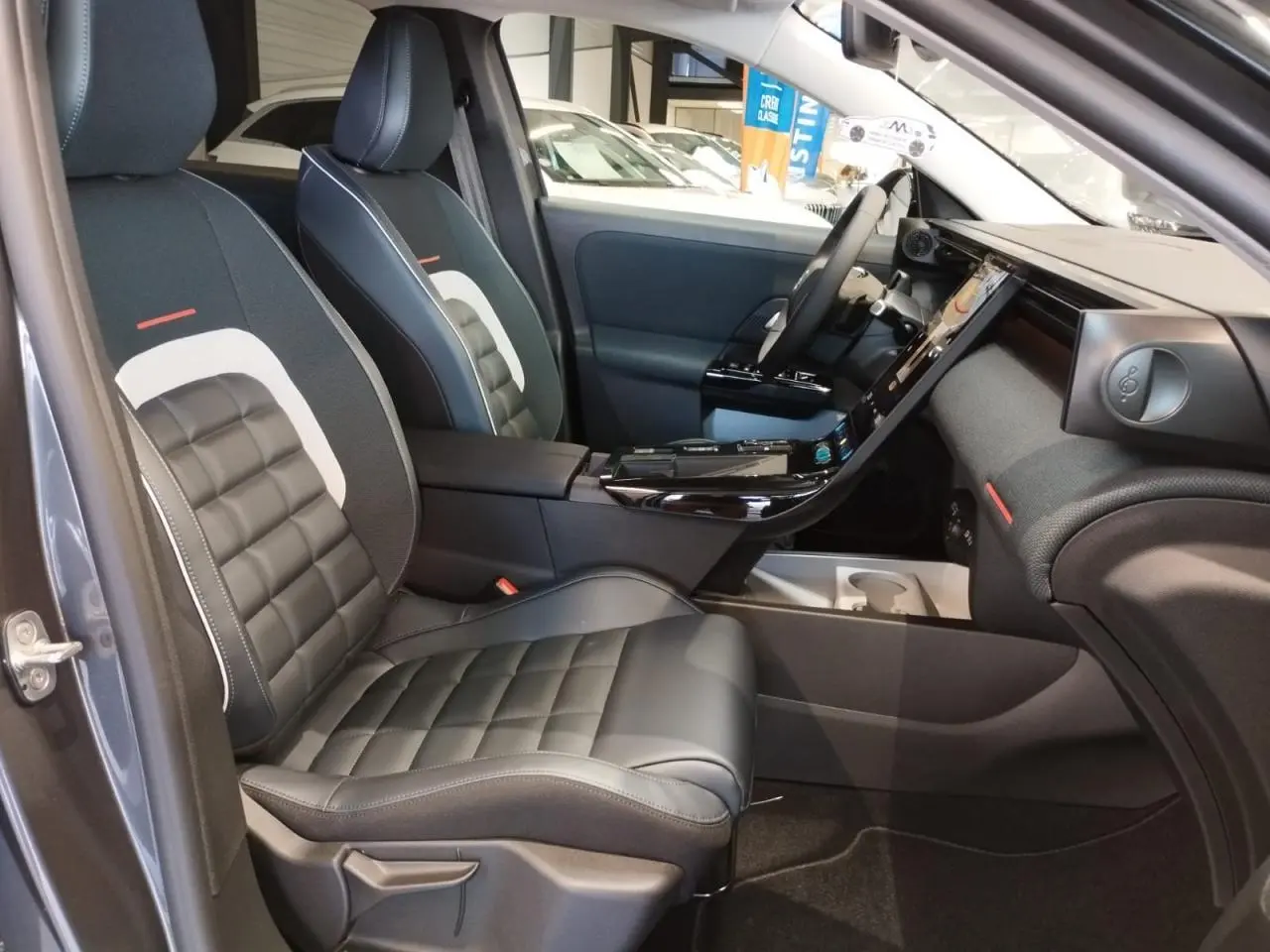 Vue intérieure côté conducteur du Citroën C5 Aircross gris platine, mettant en valeur les sièges noirs matelassés et la console centrale moderne.