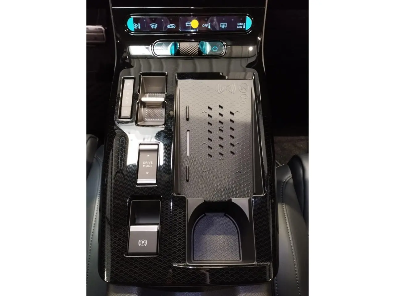Vue rapprochée de la console centrale noire brillante du Citroën C5 Aircross 2026 avec commandes et recharge sans fil.