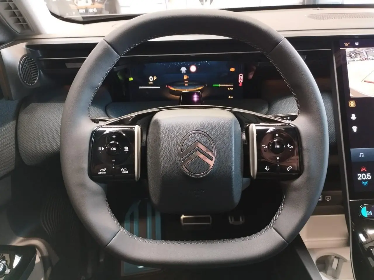 Vue rapprochée du volant multifonctions noir brillant du Citroën C5 Aircross 2026 avec tableau de bord numérique et écran tactile.