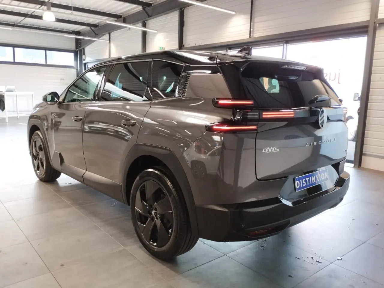 Vue 3/4 arrière droite du Citroën C5 Aircross gris platine avec feux arrière LED horizontaux et jantes noires.