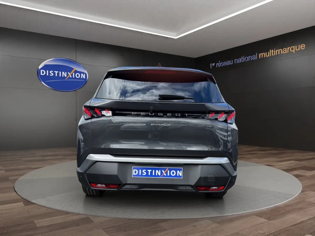 Vue arrière d'un Peugeot 5008 gris foncé avec feux LED distinctifs et logo PEUGEOT lumineux.
