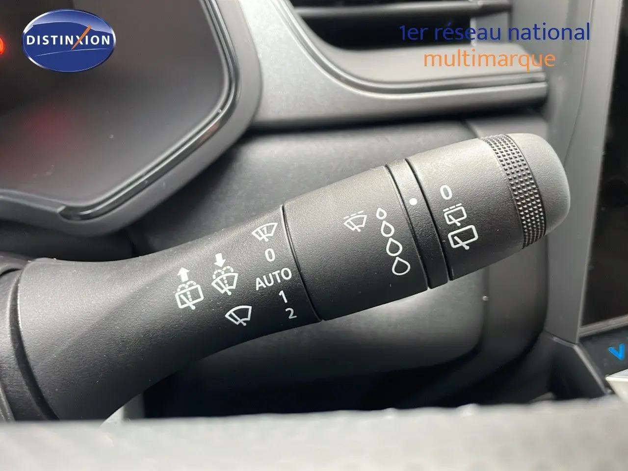 Gros plan sur la commande d'essuie-glace du Renault Captur blanc nacré, montrant les réglages automatiques et manuels.