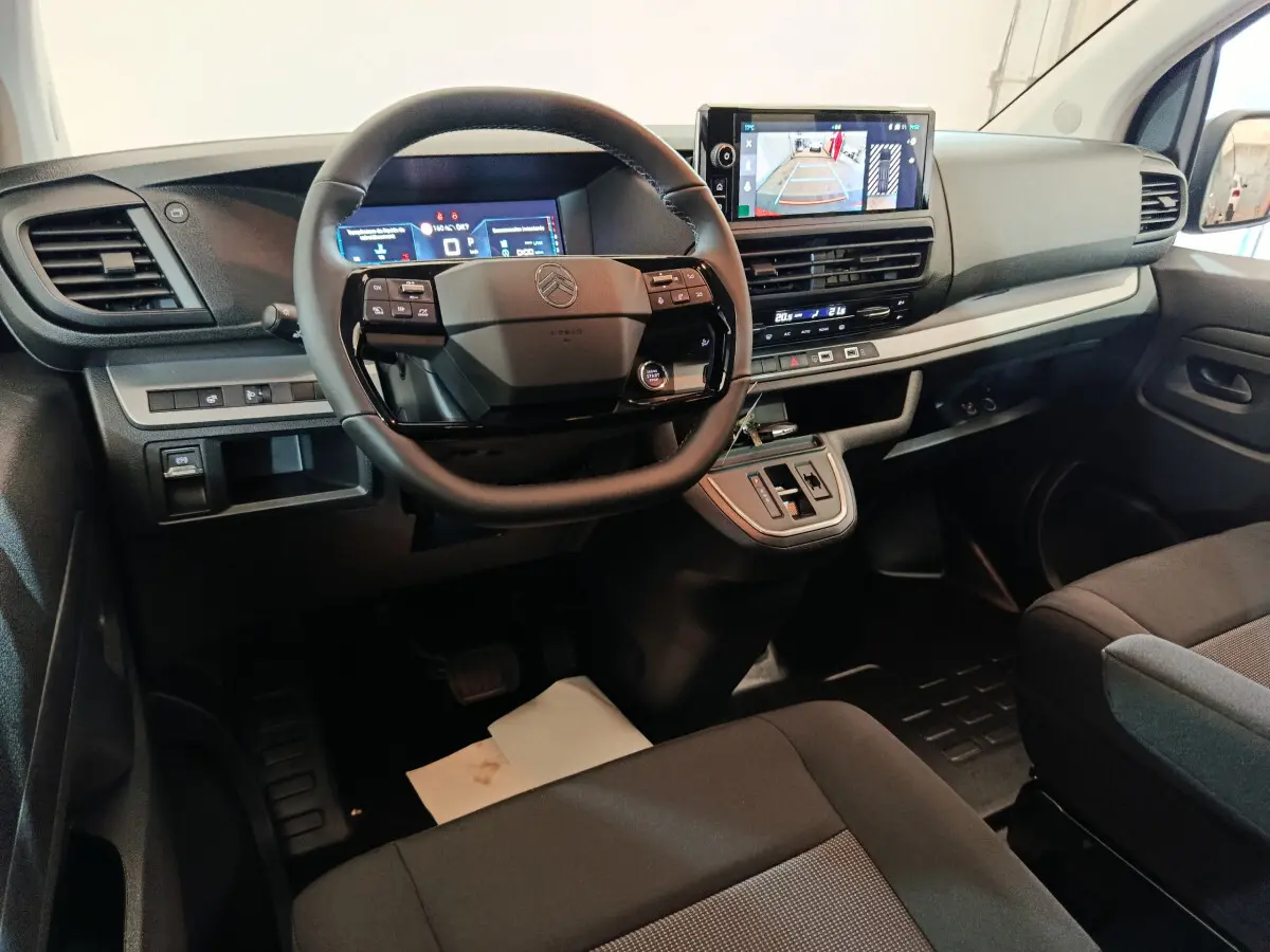 Intérieur noir du Citroën Jumpy XL 2025, vue du poste de conduite avec volant multifonction et écran tactile central.