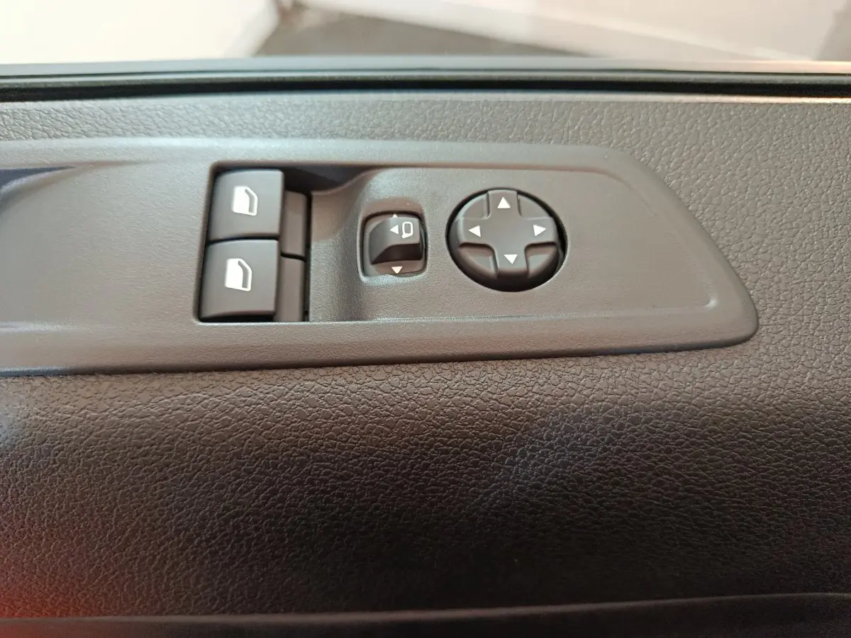 Gros plan sur les commandes de réglage des rétroviseurs et des vitres côté conducteur du Citroën Jumpy XL noir 2025.