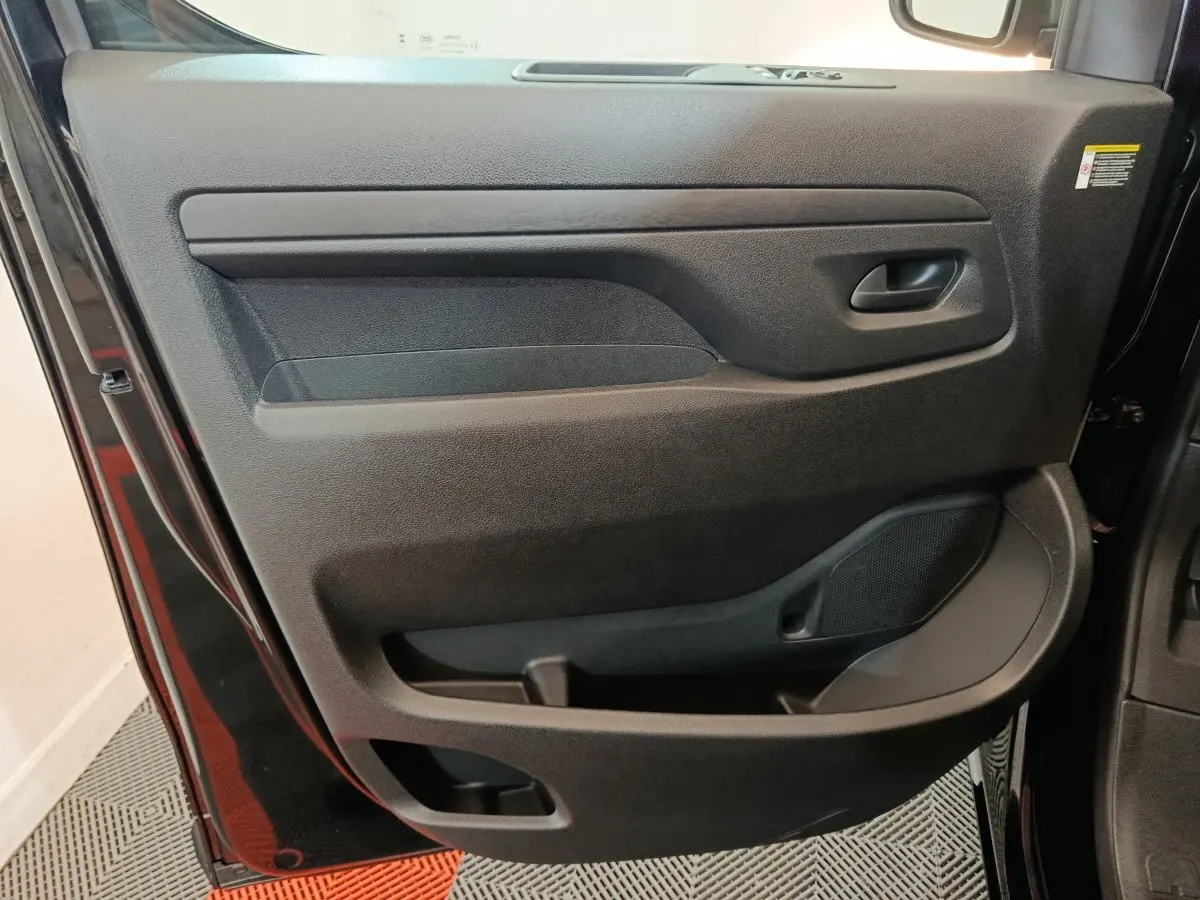 Porte intérieure côté gauche du Citroën Jumpy XL 2025 noir, avec poignée intégrée et haut-parleur visible.