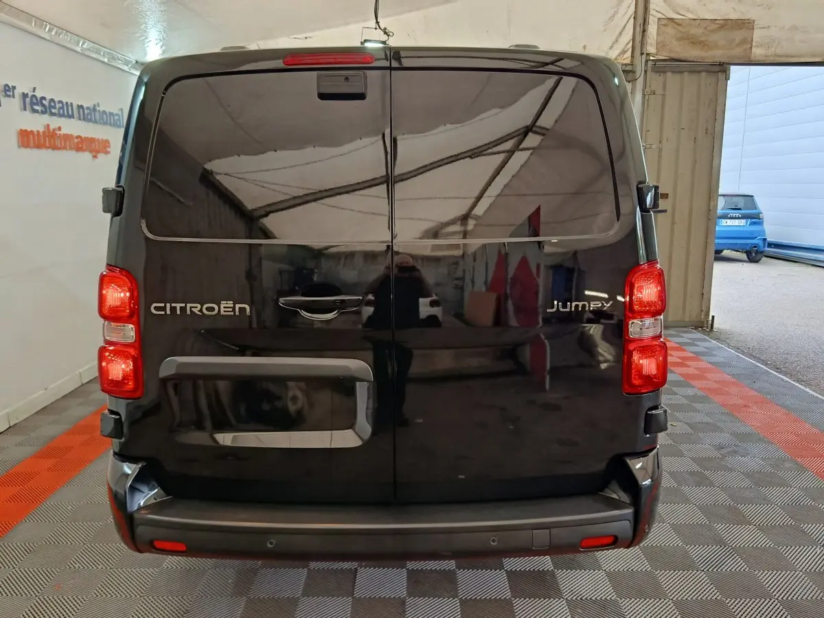 Vue arrière du Citroën Jumpy XL noir 2025 avec portes battantes et feux rouges visibles en intérieur showroom.