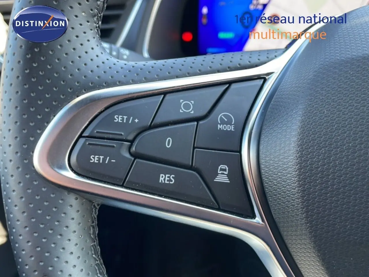 Gros plan sur les commandes de régulateur de vitesse au volant perforé du Renault Symbioz noir étoile métal.