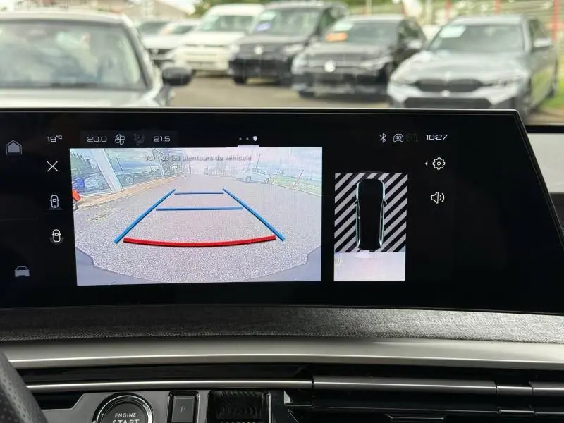 Vue intérieure du tableau de bord du Peugeot 5008 Hybrid 145ch GT, affichant la caméra de recul et l'aide au stationnement.