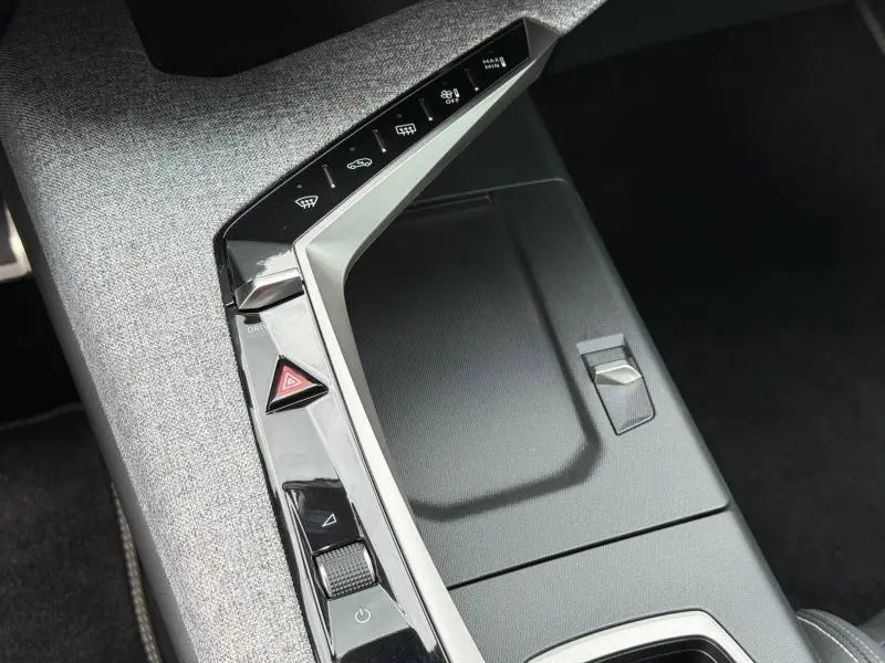 Vue rapprochée de la console centrale du Peugeot 5008 Hybrid 145ch GT 2025 avec finition tissu gris et commandes tactiles.
