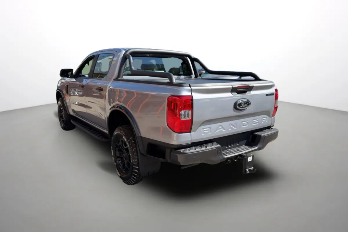 Ford Ranger gris iconic en 3/4 arrière droit, avec arceaux noirs et attelage visible sur la benne.