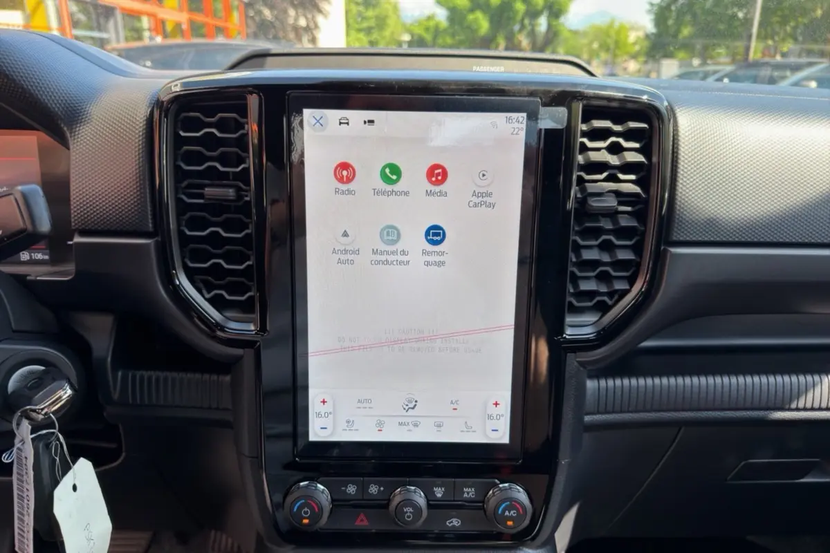 Vue intérieure du tableau de bord du Ford Ranger 2026 avec écran tactile central vertical et commandes climatisation.