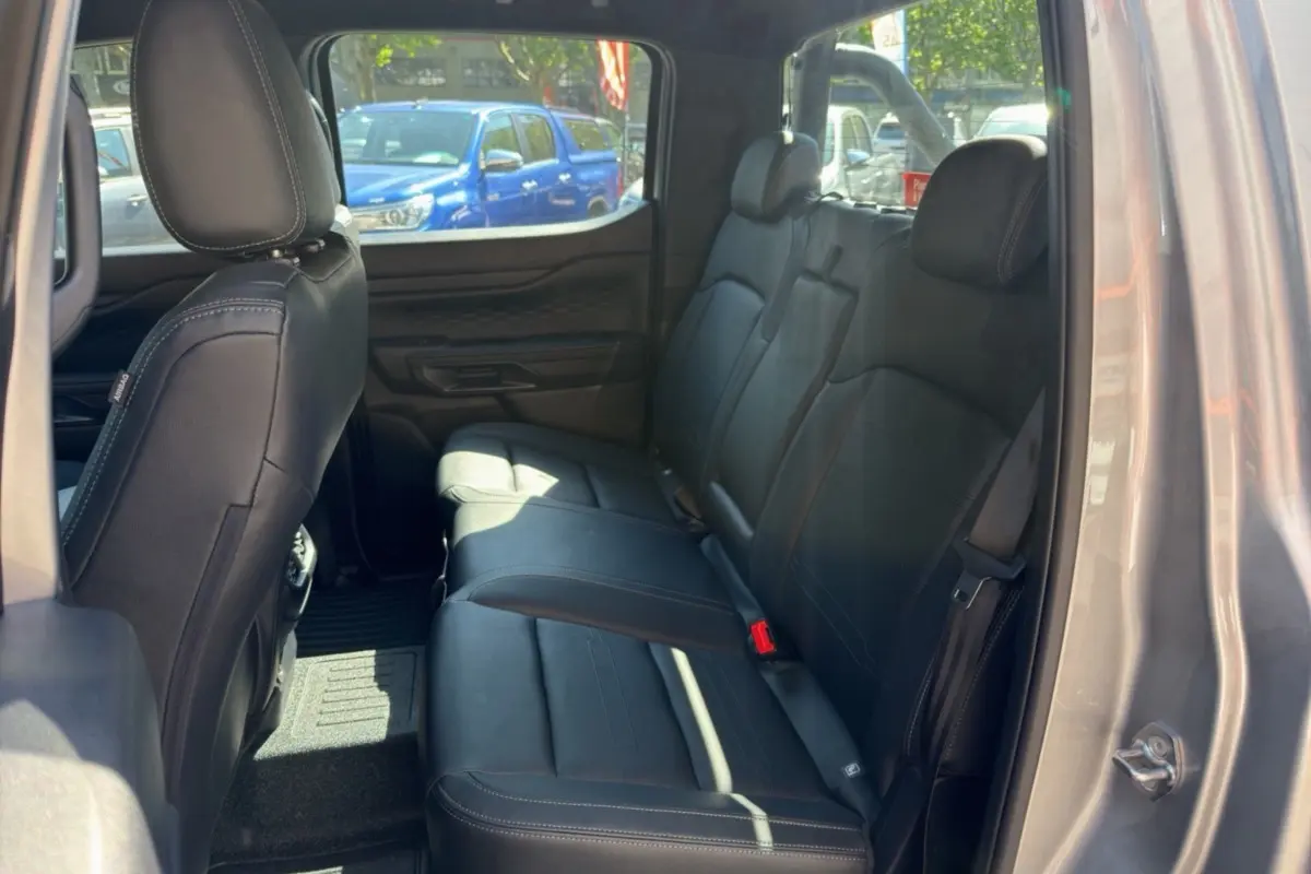 Vue intérieure arrière droite du Ford Ranger gris iconic, montrant les sièges en cuir noir et les ceintures de sécurité.