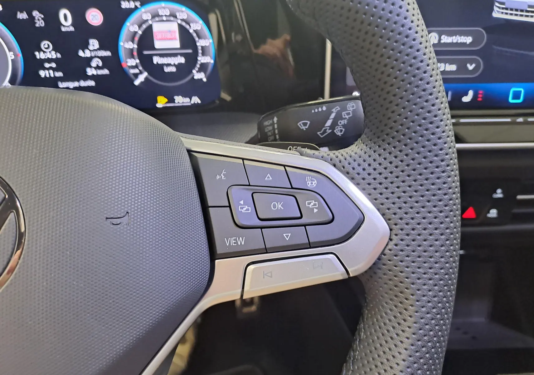 Gros plan sur le volant cuir perforé côté gauche de la Volkswagen Golf 2025 avec commandes multifonctions et affichage numérique.