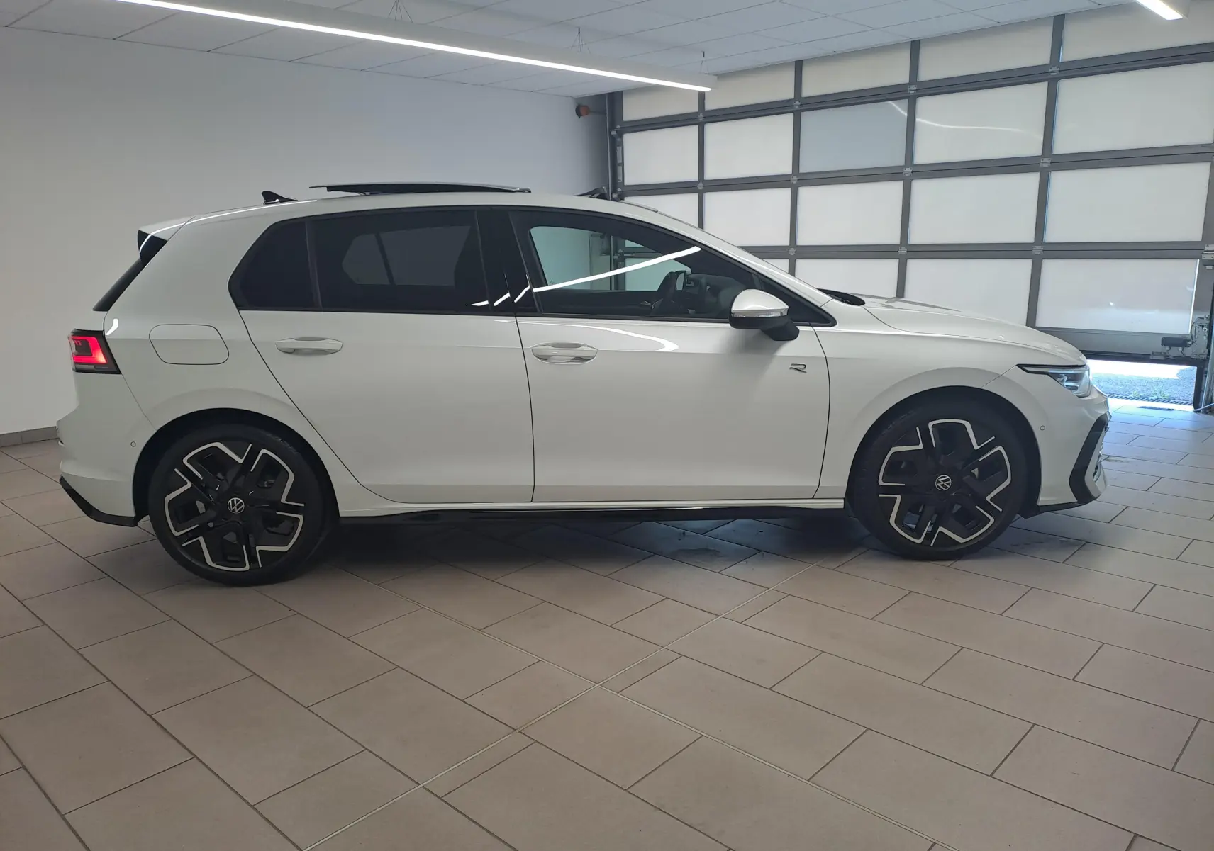 Vue de profil côté gauche d'une Volkswagen Golf 2.0 TDI blanche nacrée avec toit noir et jantes noires stylisées.