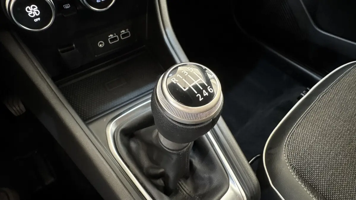 Gros plan sur le levier de vitesses manuel noir du Renault Captur Techno TCe 90, intérieur avec console centrale noire.