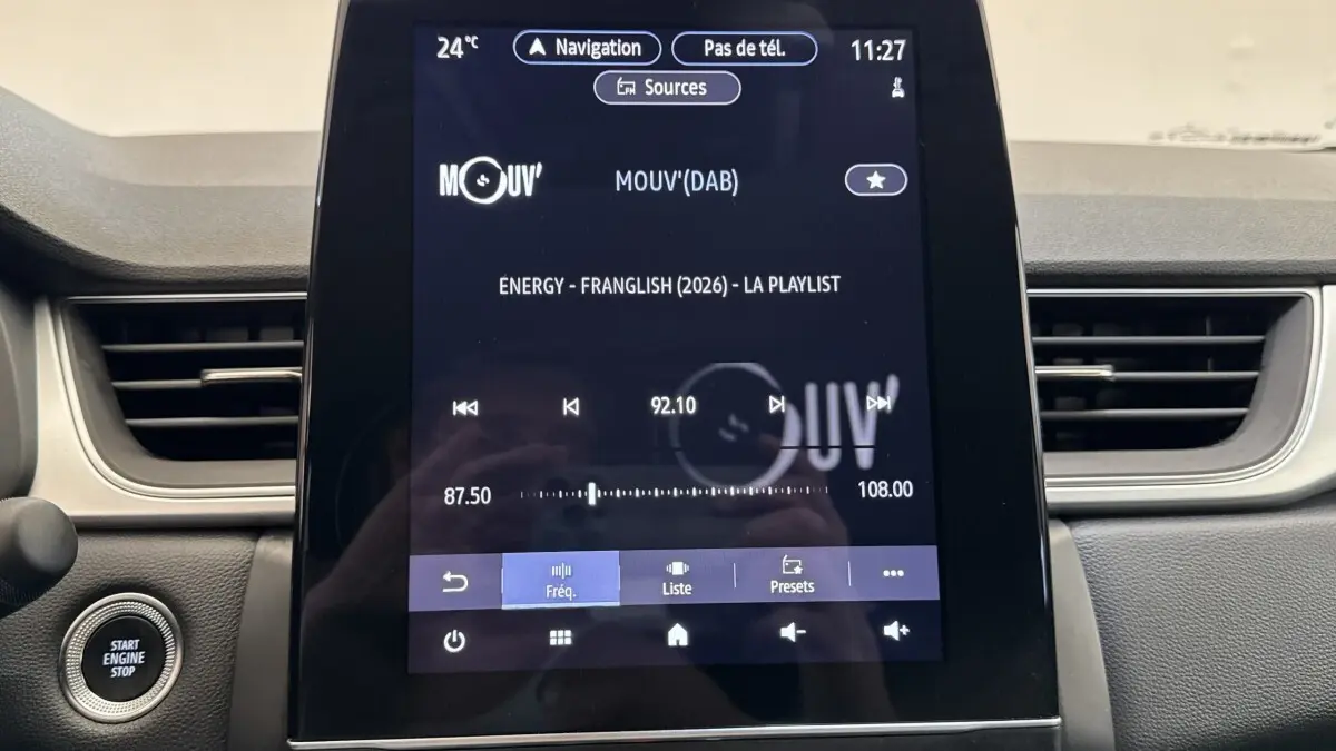 Vue rapprochée de l’écran tactile central du Renault Captur rouge 2024 affichant la radio et les commandes multimédia.