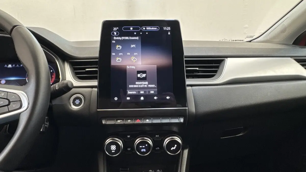 Vue intérieure du tableau de bord du Renault Captur 2024 avec écran tactile central vertical et commandes climatisation rondes.