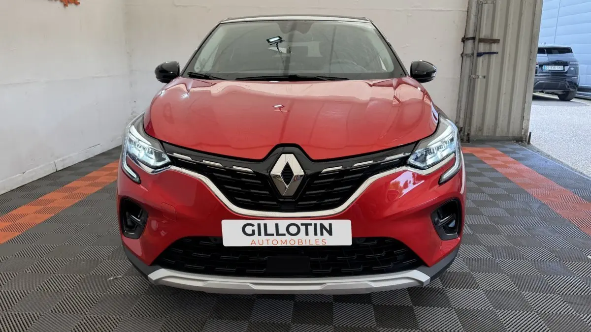 Vue frontale d'un Renault Captur rouge 2024 avec calandre noire et détails chromés, phares LED allumés.