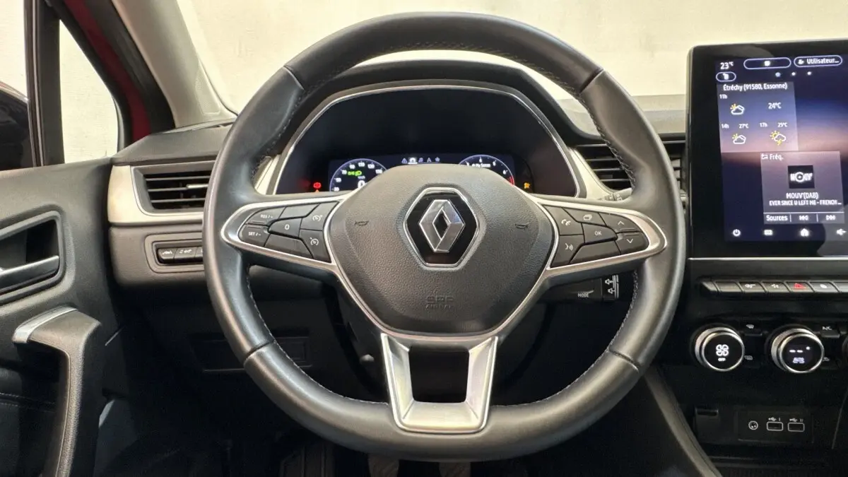 Vue centrée sur le volant noir du Renault Captur 2024 avec tableau de bord numérique et écran tactile central.