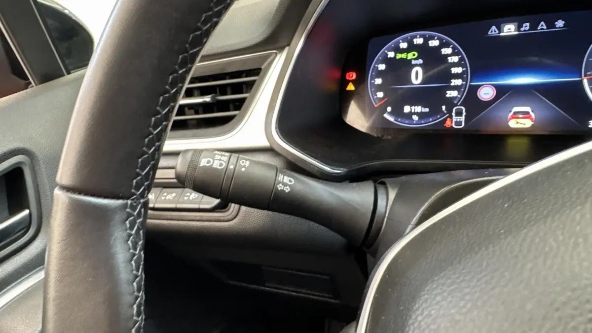 Gros plan intérieur sur le combiné d'instruments numérique et le volant noir du Renault Captur 2024 essence.