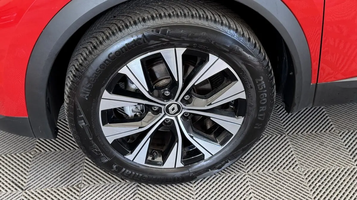 Gros plan sur la roue avant gauche du Renault Captur rouge 2024 avec jante alliage bicolore et pneu Continental.