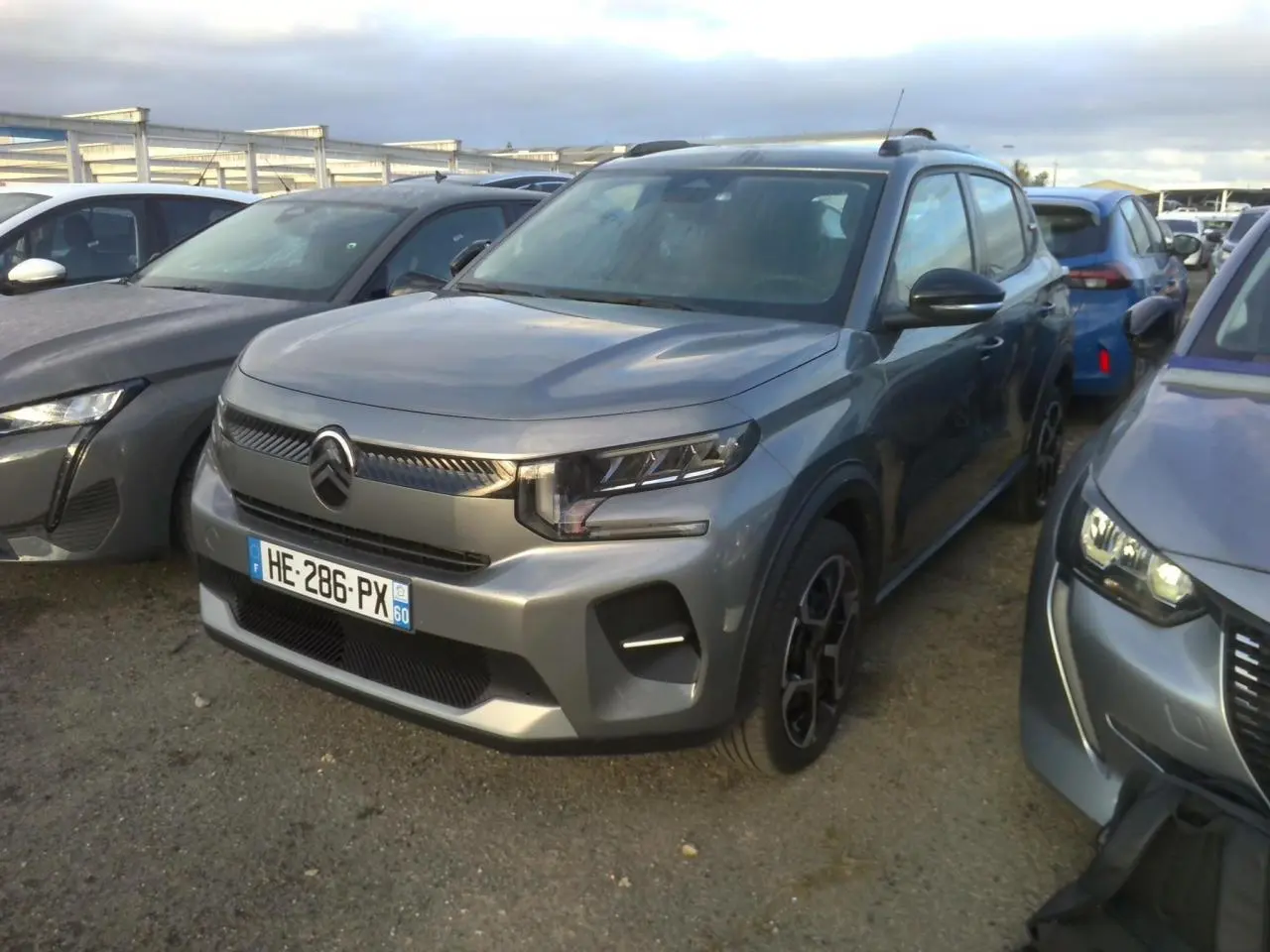 Citroën C3 2025 gris foncé vue 3/4 avant, avec barres de toit noir brillant et jantes 17 pouces Azurite.