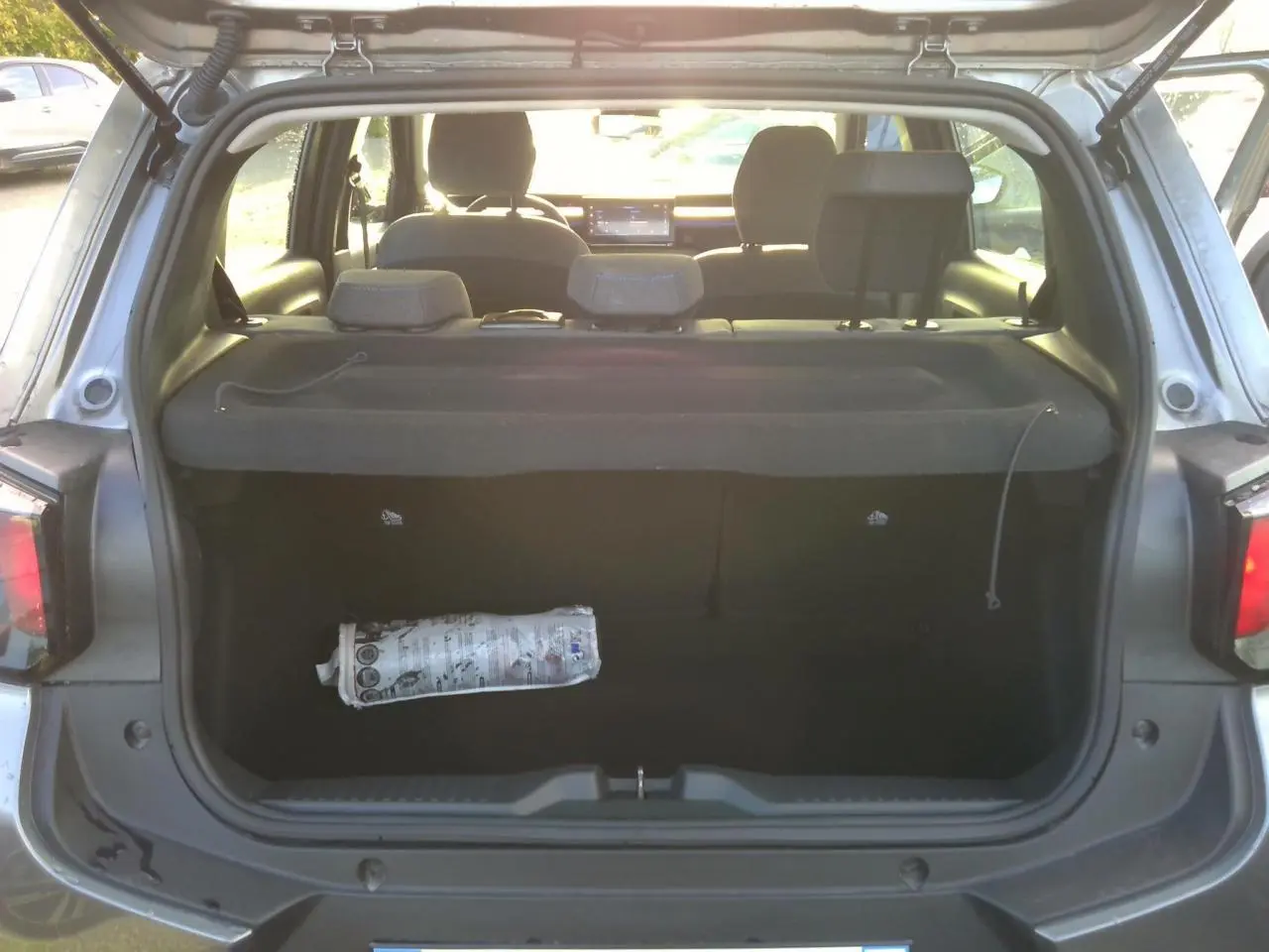 Vue arrière du coffre ouvert d'une Citroën C3 2025 gris foncé, montrant l'intérieur vide avec cache-bagages déployé.