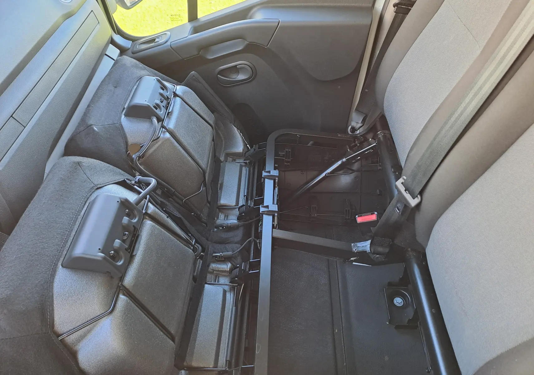 Vue intérieure côté droit du Nissan Interstar Chassis Cabine blanc 2024, montrant les sièges arrière rabattus et la ceinture de sécurité.