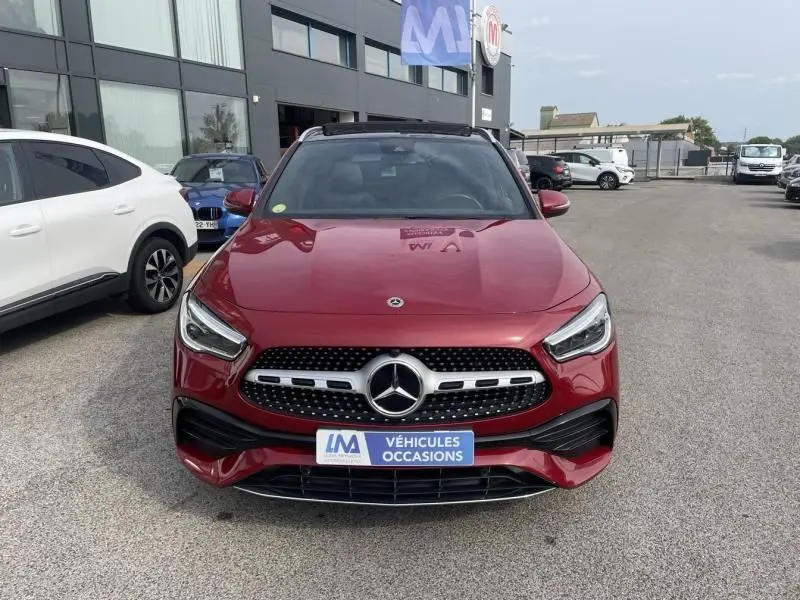 Vue de face d'un Mercedes GLA 200 D AMG-Line rouge métal 2022 avec calandre étoile et plaque "Véhicules Occasions"