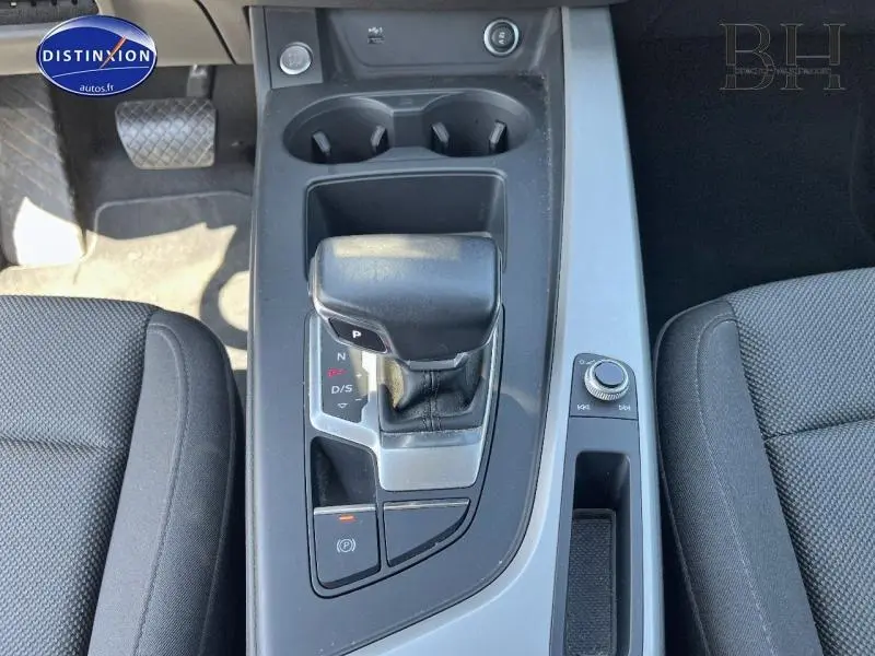 Vue plongeante sur la console centrale noire et grise de l'Audi A4 Avant 30 TDI avec levier de vitesse automatique et sièges tissu noirs.