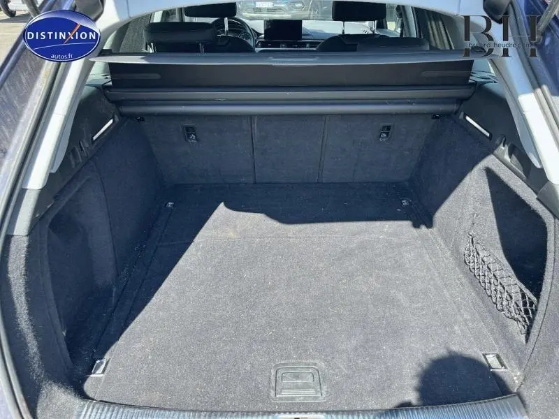 Vue intérieure du coffre spacieux et propre de l'Audi A4 Avant 30 TDI bleu Navarre métallisé, avec filet latéral de rangement.