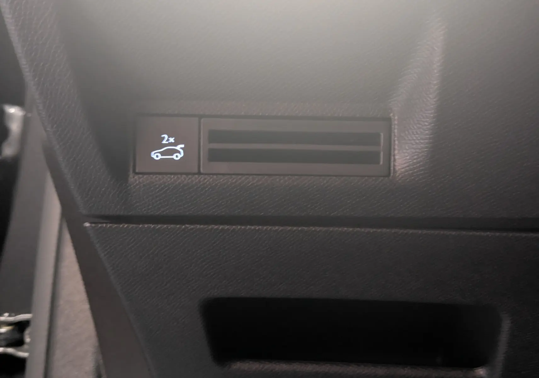 Détail du tableau de bord côté gauche du Peugeot 3008 Hybrid 145 GT 2025 avec bouton d'ouverture du coffre visible.