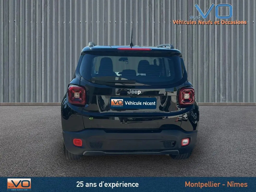 Vue arrière d'un Jeep Renegade noir 2024 avec barres de toit et jantes alliage 18 pouces sur sol goudronné.