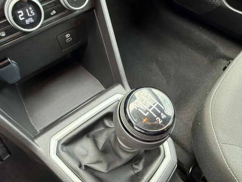 Gros plan sur le levier de vitesses manuel du Dacia Jogger gris, avec console centrale et partie du siège côté droit visibles.